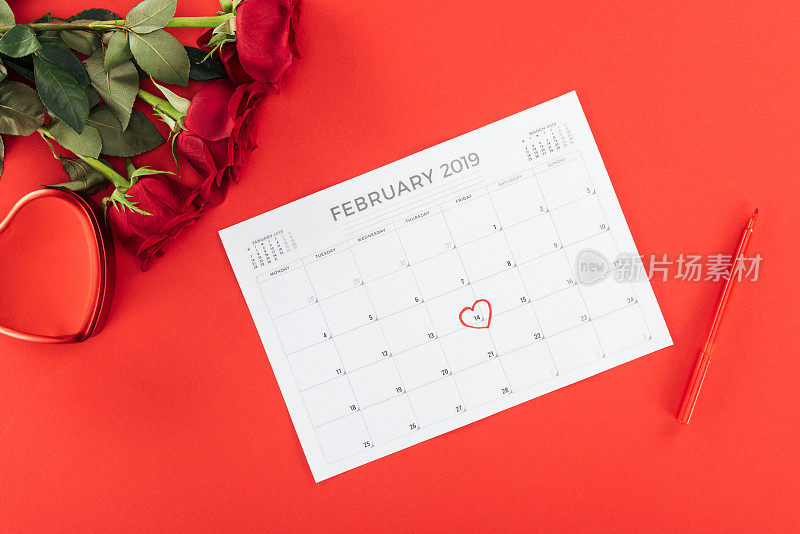 Top view of roses and calendar with 14 February date marked with heart isolated on red, st valentine day概念